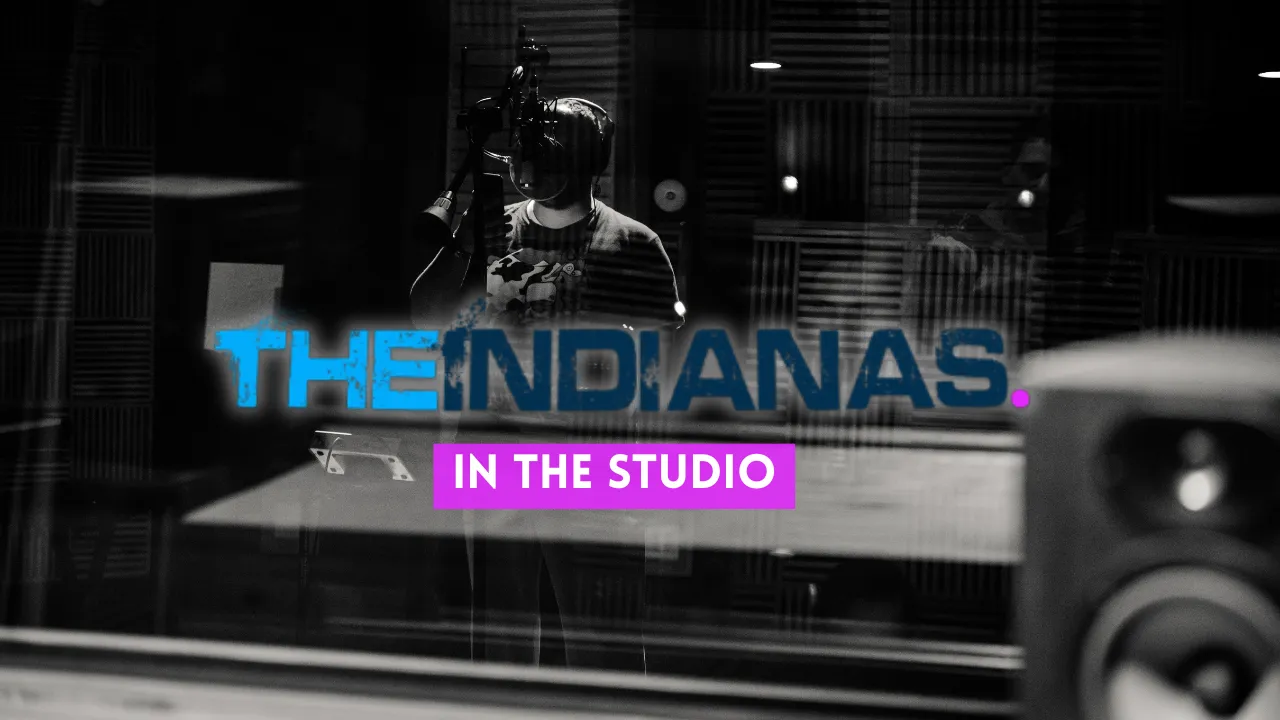 Black and white photo of a person singing into a studio microphone with 'THE INDIANAS. IN THE STUDIO' text overlay.